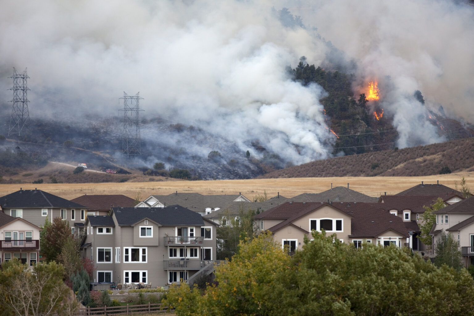 Photo of large wildfire behind apartment complex.